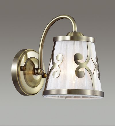 Настенный светильник бра Lumion 3285/1W FETIDA Настенный светильник бра Lumion 3285/1W FETIDAСовременные<br>Бра 3127/1W серии Fetida оформлена в классическом стиле. Светильник состоит из абажура из органзы, украшенного изящным металлическим декором и классической арматуры бронзового цвета. Классика формы и цвета позволит данной модели стать украшением любой комнаты. Цоколь E14. Мощность 1х60W. Нет ламп в комплекте.<br><br>Крепление: Настенное<br>Тип лампы: накаливания / энергосбережения / LED-светодиодная<br>Тип цоколя: E14<br>Количество ламп: 1<br>MAX мощность ламп, Вт: 60<br>Цвет арматуры: бронзовый